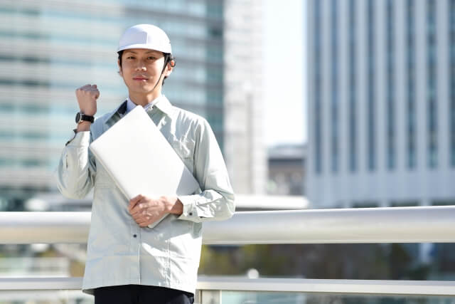 作業服を着てファイルを持つ人物